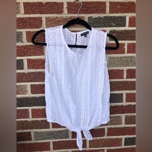Tie in front, white eyelet sleeveless shirt. Size is a medium, hardly worn.